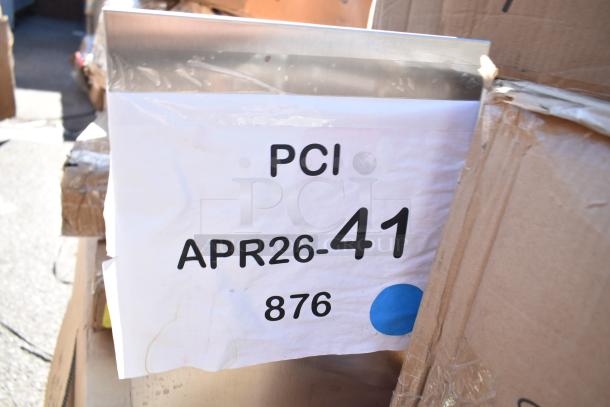 Alt text: Auction lot with boxes labeled "PCI APR26-41 876," containing 16 new scratch and dent items, including a wire shelf.