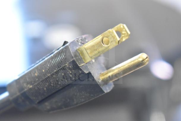 2017 Hobart HTi-7LH26 commercial food scale plug, showing standard prongs, clean and operational condition.