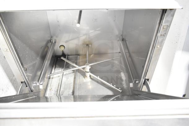 Jackson Avenger undercounter dishwasher interior view showing metal spray arm and filter in good condition.