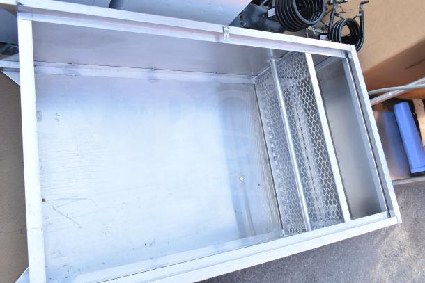 Metal locker cubby, sturdy construction, open top view, mesh side panel, some wear visible; ideal for storage needs.