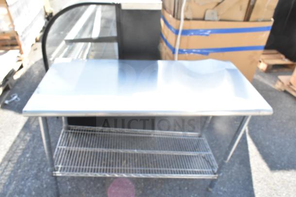 Commercial table with stainless steel top and wire under shelf, sturdy metal legs, good condition. Ideal for kitchen or workshop.