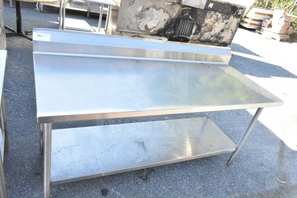 Stainless steel commercial table with under shelf and backsplash, good condition. Ideal for kitchen use.