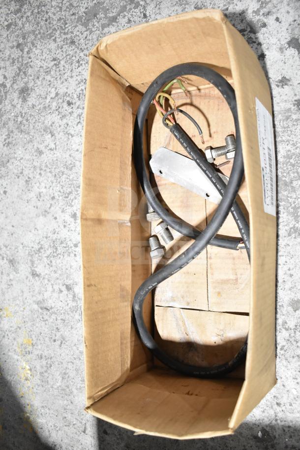A cardboard box containing miscellaneous electrical cables, connectors, and wiring components.