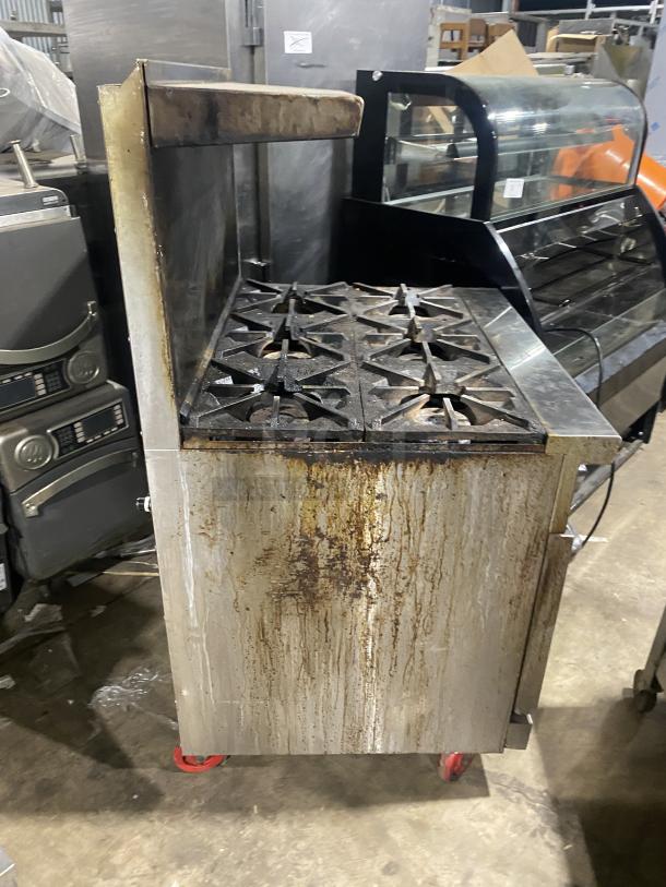 Migali C-RO6B-NG commercial 6-burner gas stove with raised backsplash, salamander shelf, and oven. Stainless steel on casters.