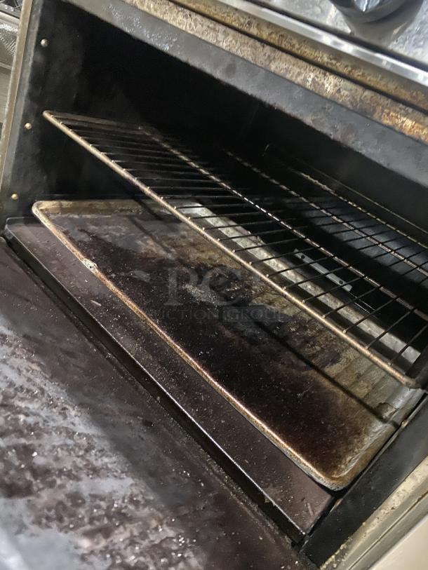Interior view of Migali CRO6B stainless steel commercial oven, showing racks and signs of use.