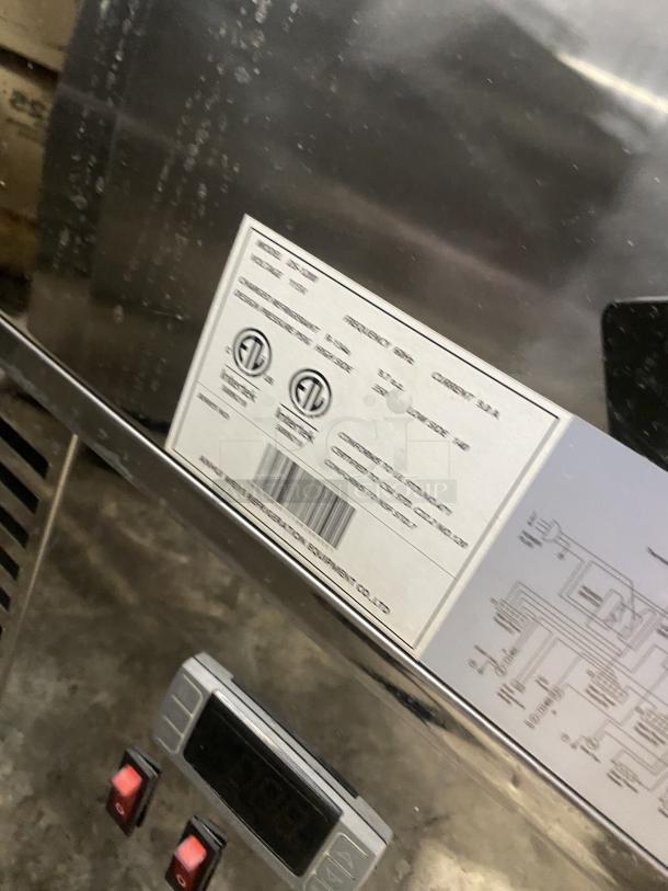 Commercial black dual service glass refrigerated display case with visible labels indicating specifications and ETL certification.