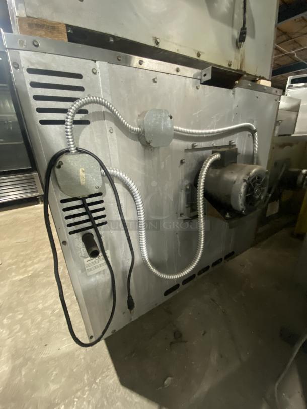 Majestic Series stainless steel commercial convection oven back view, features wired racks, utility cables visible, used condition.