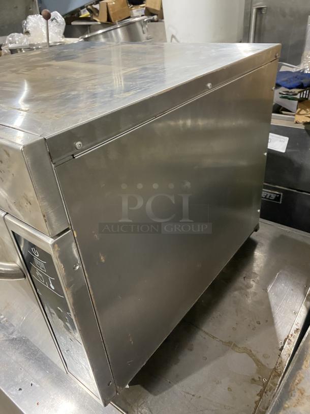 Amana AXP22 commercial stainless steel microwave oven, used condition, 208-230V, model and serial numbers visible.