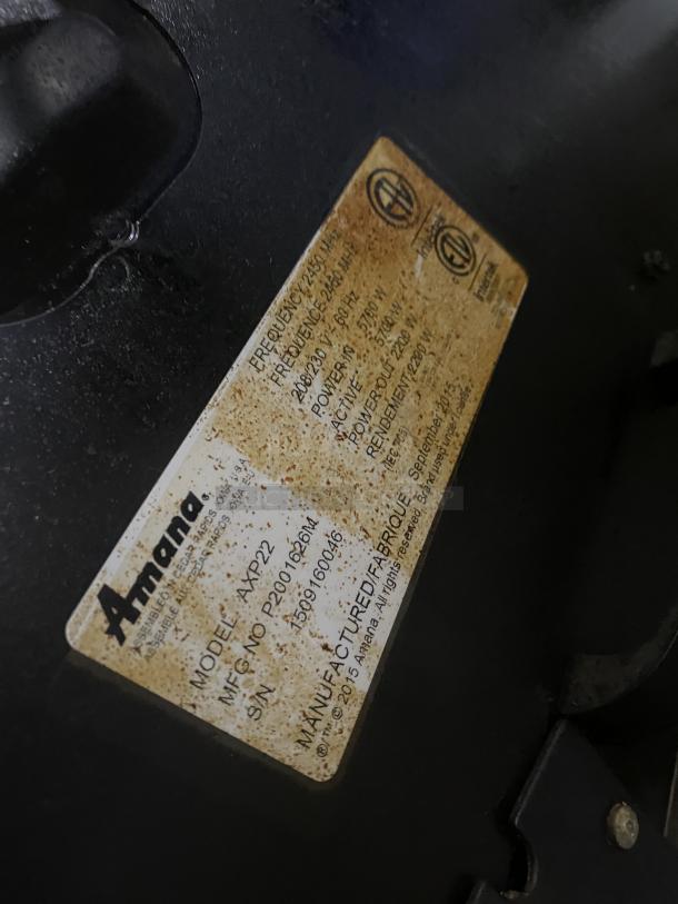 Amana model AXP22 stainless steel microwave oven label, showing serial number 1509160046 and voltage details.