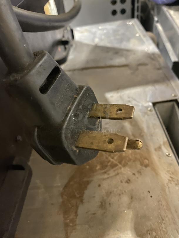 Close-up image of a plug for an Amana AXP22 commercial countertop microwave. Plug shows signs of wear.