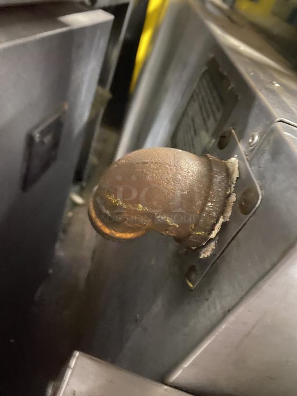 Rusty metal pipe connection on an Amana GP-61 oven. The photo lacks a view of the entire oven.