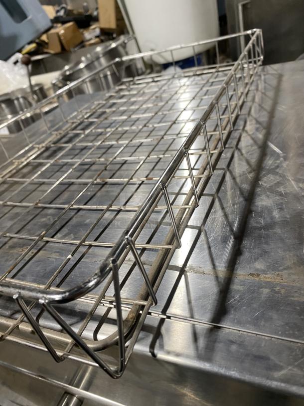 Stainless steel commercial rack for bagel wraps, grid design, excellent condition, ideal for food service use.
