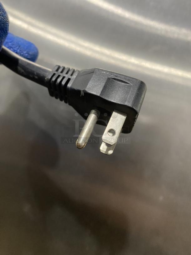 Close-up of the power plug for a Maxx Cold MXCF-49FD freezer, showing standard prongs and insulated cable.