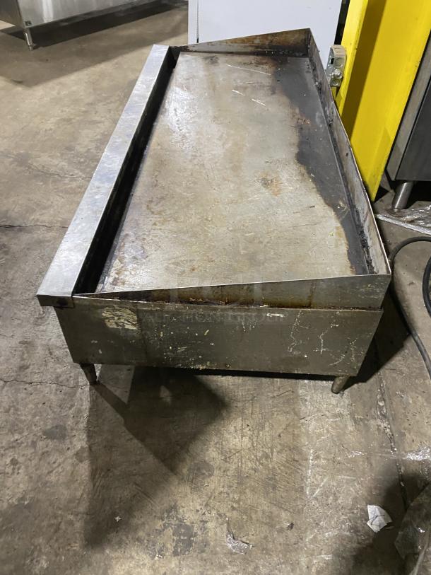 Garland commercial stainless steel countertop griddle on legs, used condition, visible surface wear, sturdy build.