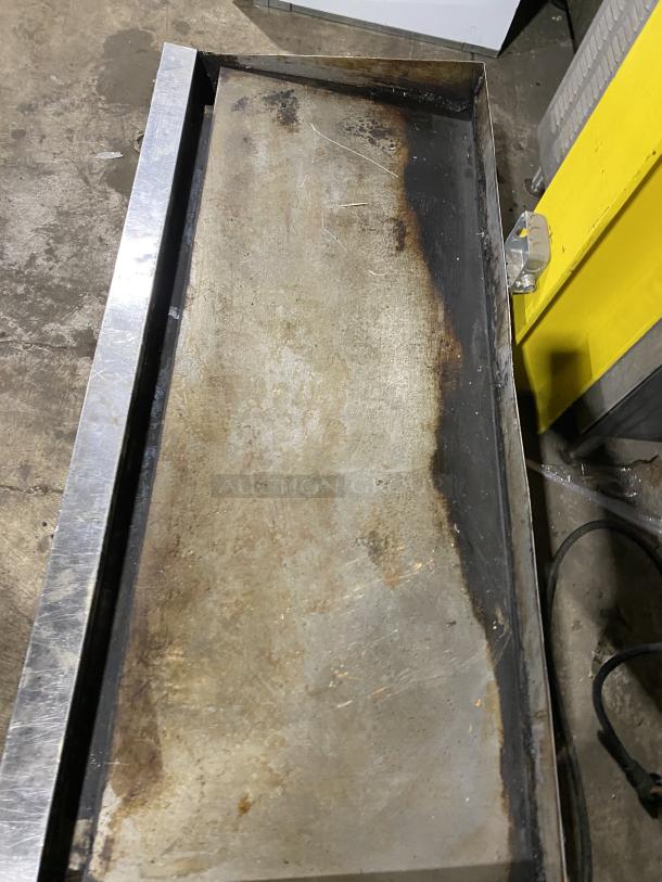 Garland commercial stainless steel countertop griddle on legs. Shows signs of use with discoloration. Ideal for heavy-duty cooking.