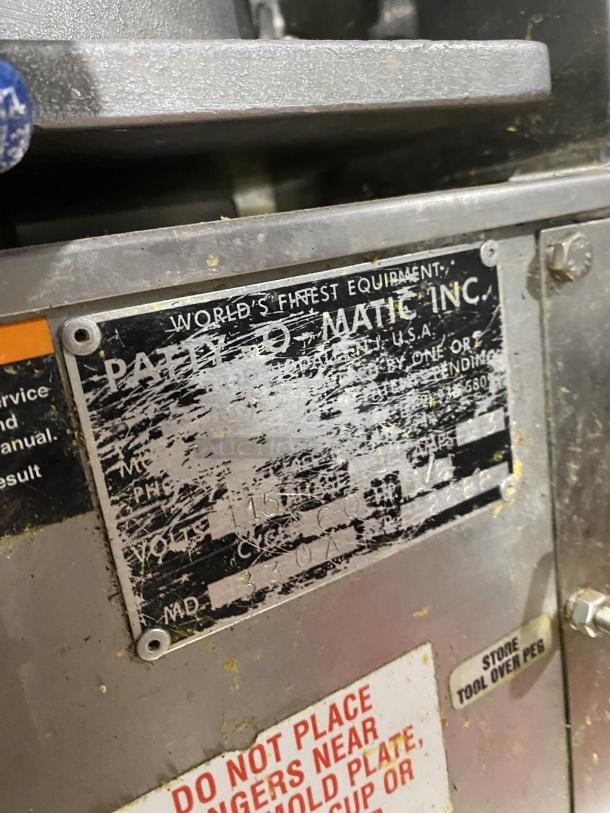 Patty O Matic Model 330A stainless steel meat forming machine, 115V, on casters. Visible manufacturer's label shows model and voltage.