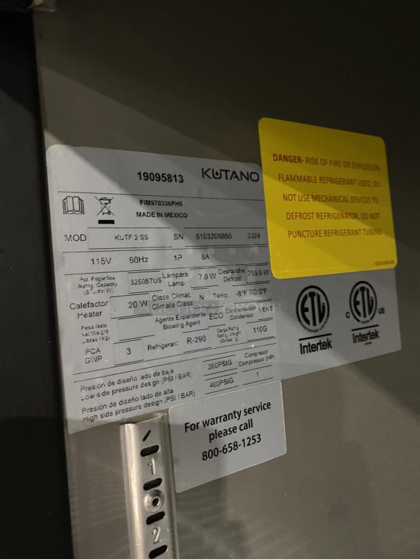 Kutano KUTF 2 SS stainless steel commercial freezer label, showing model, SN 8103206950, 115V, 1 Phase, and warranty info.