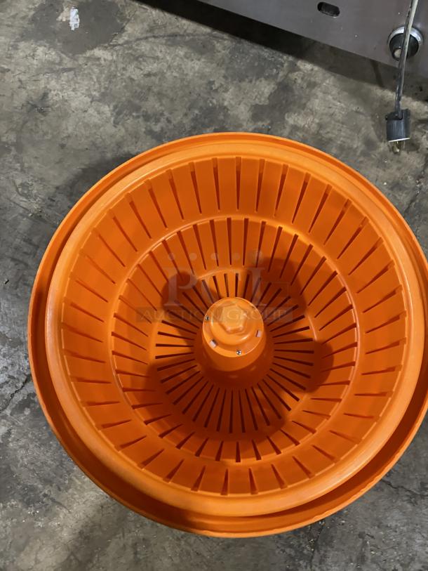 Orange commercial salad spinner/dryer with ribbed interior, in good condition. Ideal for large volume salad preparation.