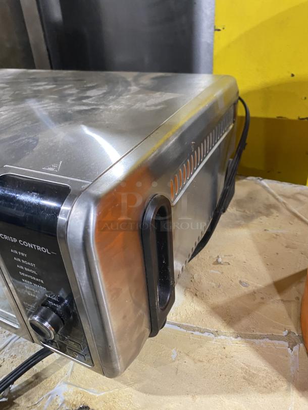 Ninja Countertop Digital Air Fry Oven, Model FT102CO, stainless steel, view-through door, crisp control dial visible.