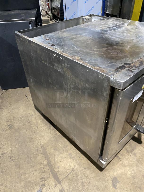 Alto-Shaam stainless steel commercial oven with wired rack, natural gas-powered, on casters, showing surface wear. SN: 710358-002.