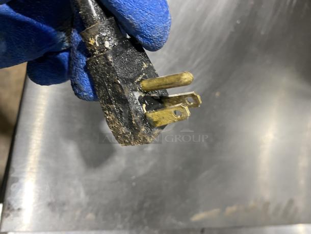 Close-up of a power plug for a Hoshizaki CRMR48-12 commercial refrigerator. Plug shows signs of wear.