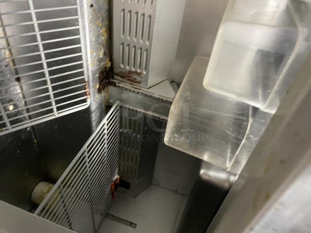 Hoshizaki CRMR48-12 stainless steel commercial refrigerator interior with top rail. Shelving shows signs of wear.