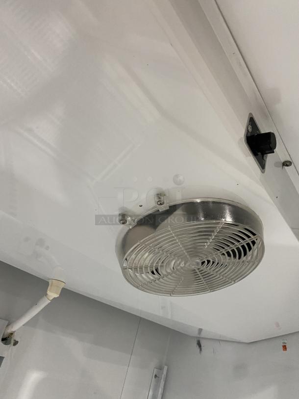 Interior view of Master-Bilt BMG-48 merchandiser fridge with fan and wiring. Poly-coated rack and white finish visible.