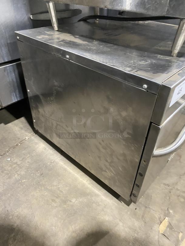 Amana commercial stainless steel microwave oven, 208-230V, shows signs of use. Suitable for heavy-duty kitchen needs.