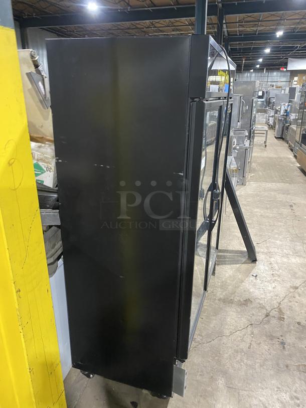 True GDM-49F-HCX-TSLO1 black double glass door merchandiser freezer with poly coated racks. Model SN: 9330944, 208-230V, 1 Phase.