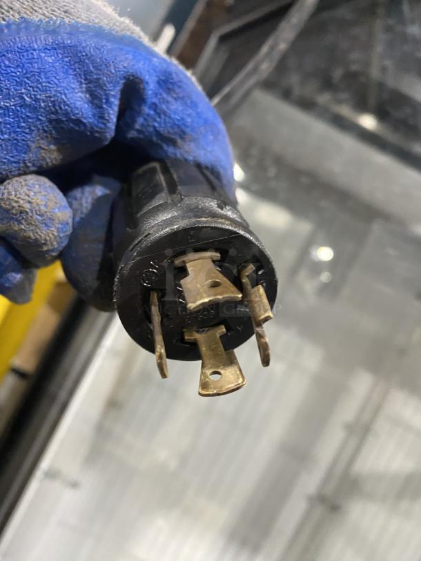 Close-up of an electrical plug for a True commercial freezer, model GDM-49F-HCX-TSLO1, showing prongs and wiring.