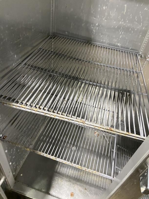 True Commercial Series stainless steel refrigerator interior, Model STG2R-2G. Visible wear and two wire shelves.