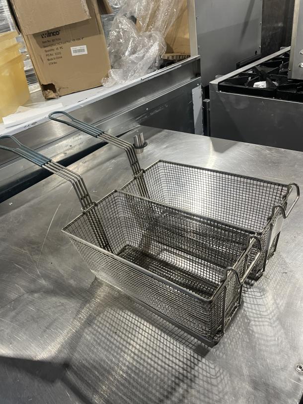 Two commercial deep fryer baskets with sturdy metal mesh and ergonomic handles, in excellent condition.
