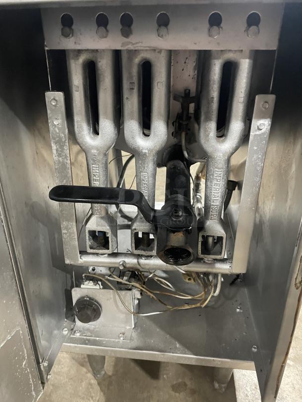Imperial stainless steel natural gas deep fat fryer, includes back splash and basket hanger, shown with internal burner components.
