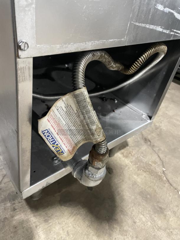 Imperial commercial stainless steel natural gas deep fat fryer, features back splash, basket hanger, legs, visible gas line.