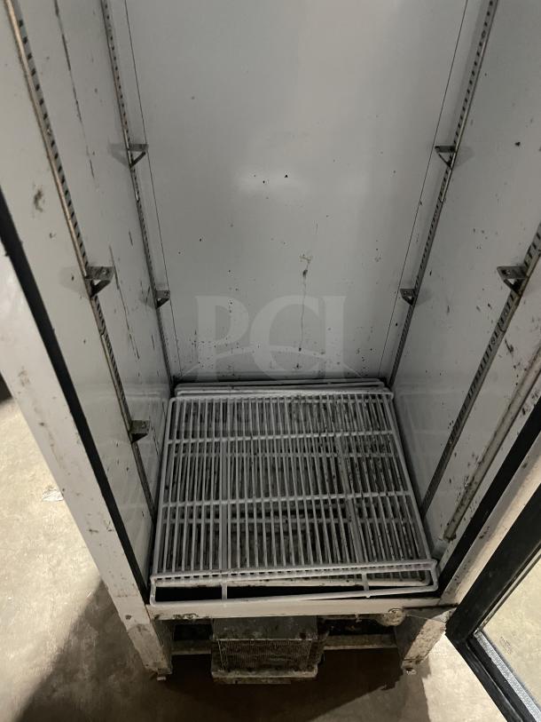 Everest EMGR10 reach-in freezer, single glass door, poly-coated wire racks, commercial use, interior view, used condition.