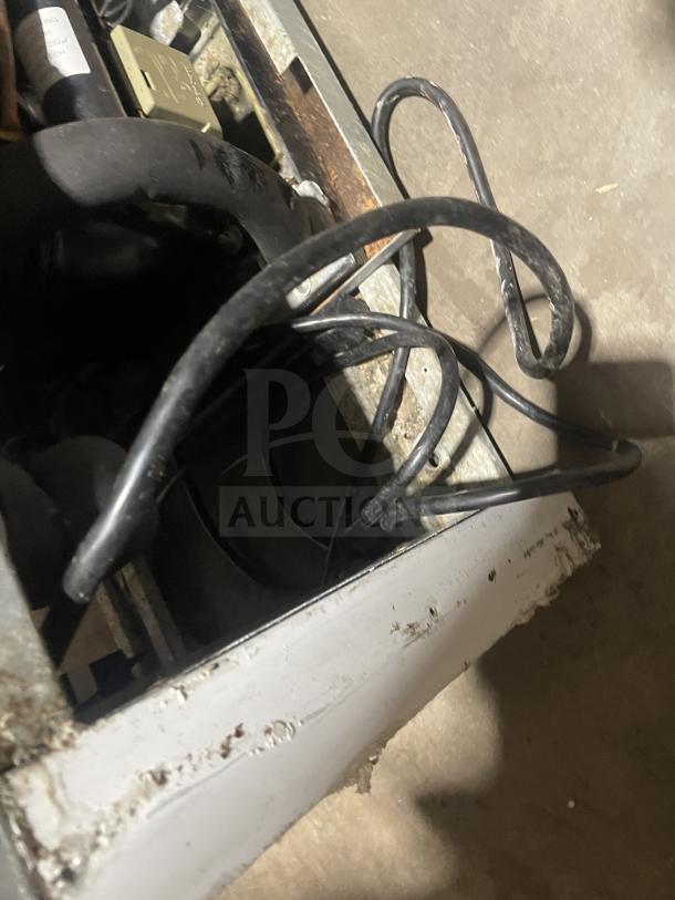 Close-up of Everest EMGR10 freezer base showing wiring and components. Rust and wear visible, indicating used condition.