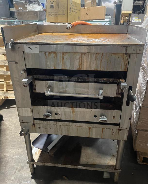 Montague commercial stainless steel countertop gas char broiler, model C36SHB, on legs with storage, on casters, showing wear.