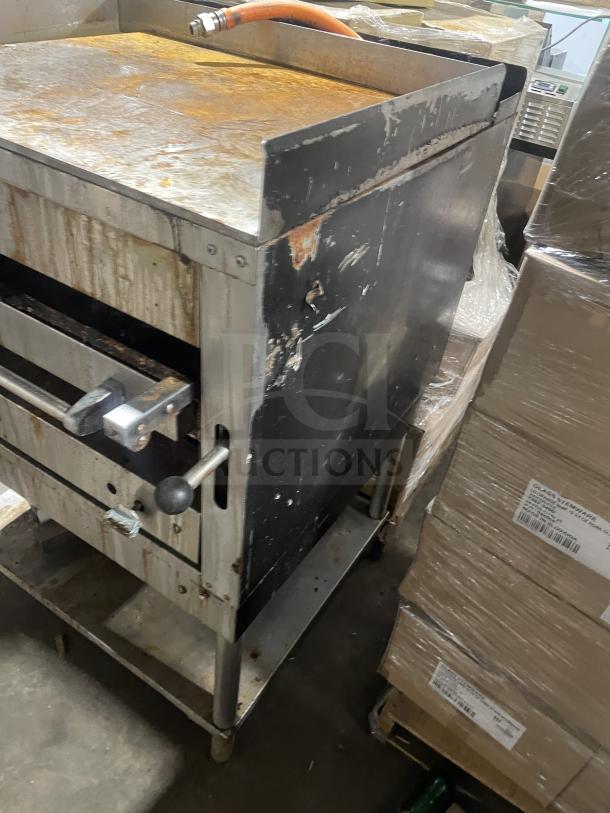 Montague stainless steel countertop gas char broiler grill, model C36SHB SN A8-D-73003A, on legs with storage, on casters.