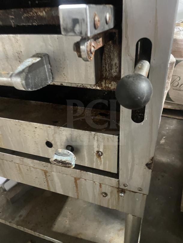 Montague C36SHB stainless steel gas char broiler grill on equipment stand, visible wear and rust on handles and structure.