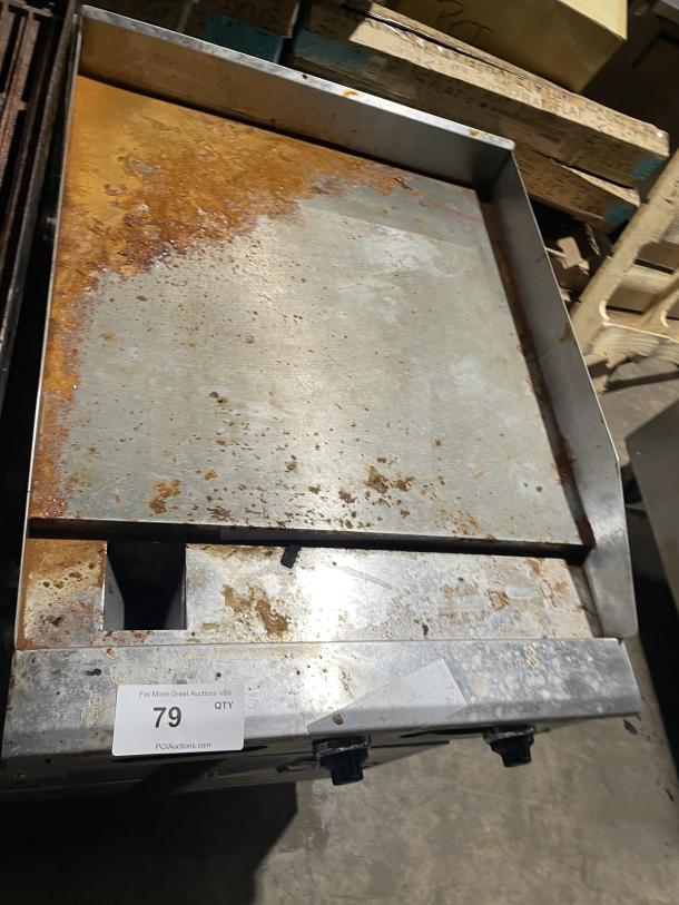 American Range AETG-124-24XT commercial stainless steel countertop flat griddle, natural gas-powered, with back and side splash. Shows signs of use; on casters. Tag marked "79."
