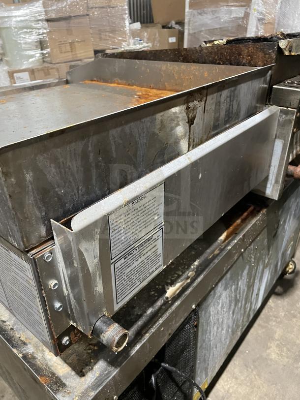 American Range AETG-124-24XT stainless steel gas flat griddle with back and side splash; visible wear, on casters.