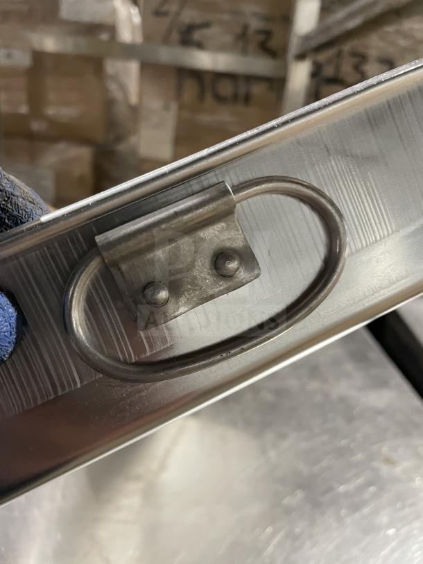 Winco commercial stainless steel bake pan, durable handle, slightly scuffed surface, ideal for professional baking.