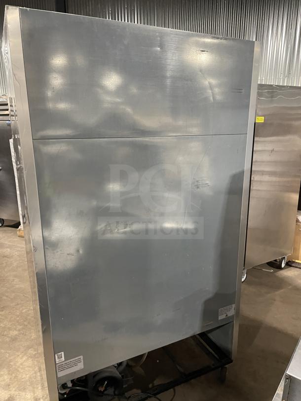 True T-43-HC commercial stainless steel 2-door reach-in refrigerator with poly-coated wire rack, on casters. Appears worn.