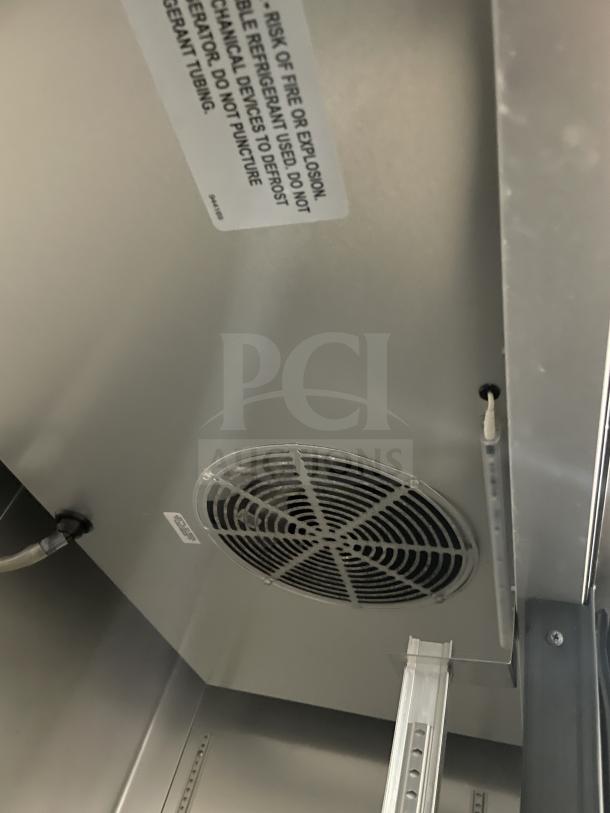 True T-43-HC commercial refrigerator interior with ventilation fan, poly-coated wired rack, model label, and risk warning.