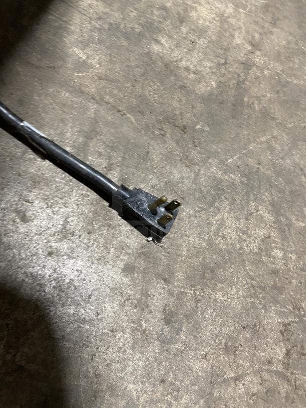 Power plug of True T-43-HC commercial refrigerator on concrete floor. 115V, 1 Phase, 60HZ connection.