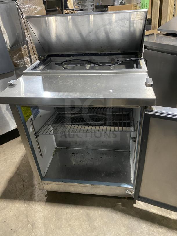 Kelvinator Model KCHST278 stainless steel refrigerated salad/sandwich prep table with wired rack, single door, and casters.