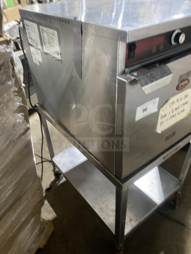 FWE Handy Line Series stainless steel electric 4-pan heated holding cabinet, Model HLC18264UC, on casters and shelf.
