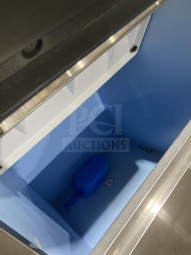 Hoshizaki KM660MAJ ice machine bin interior with a blue scoop, stainless steel exterior, and model details visible.