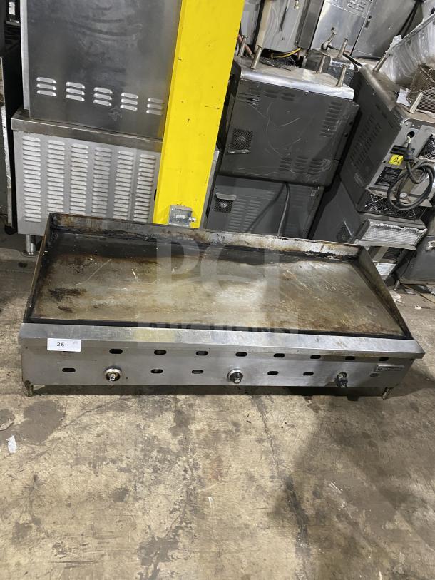 Garland stainless steel countertop griddle on legs. Used condition, visible wear. Three control knobs, auction tag "25" visible.