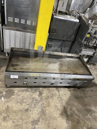 Garland stainless steel countertop griddle on legs. Used condition, visible wear. Three control knobs, auction tag "25" visible.